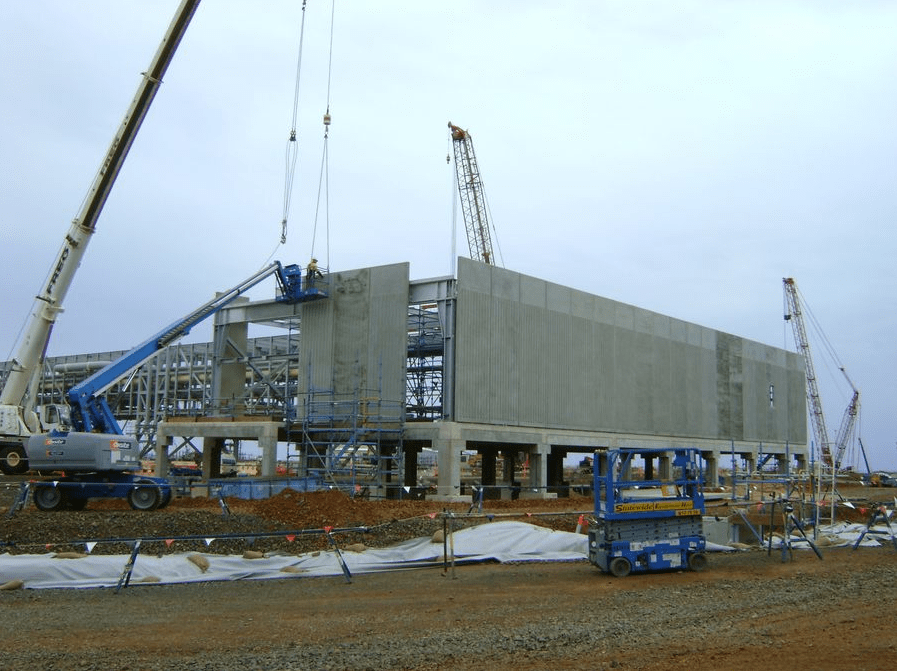 This is a photograph of the construction of the Pluto LNG Plant underway through the use of cranes and large scale scaffolding.