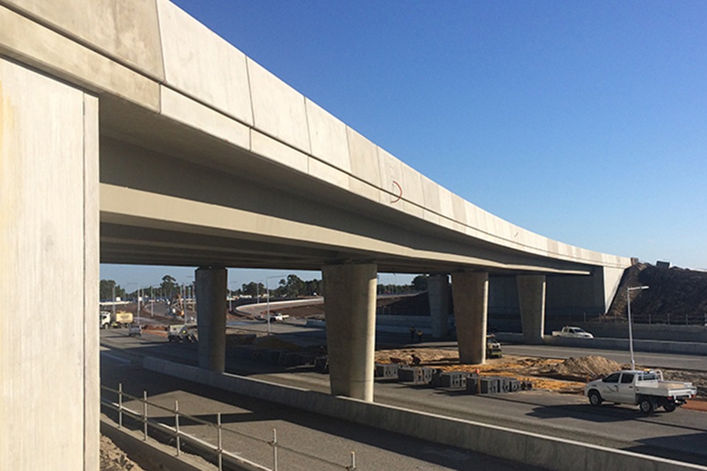 The photograph is of a newly built cement overpass completed by Monford that stretches across the freeway.