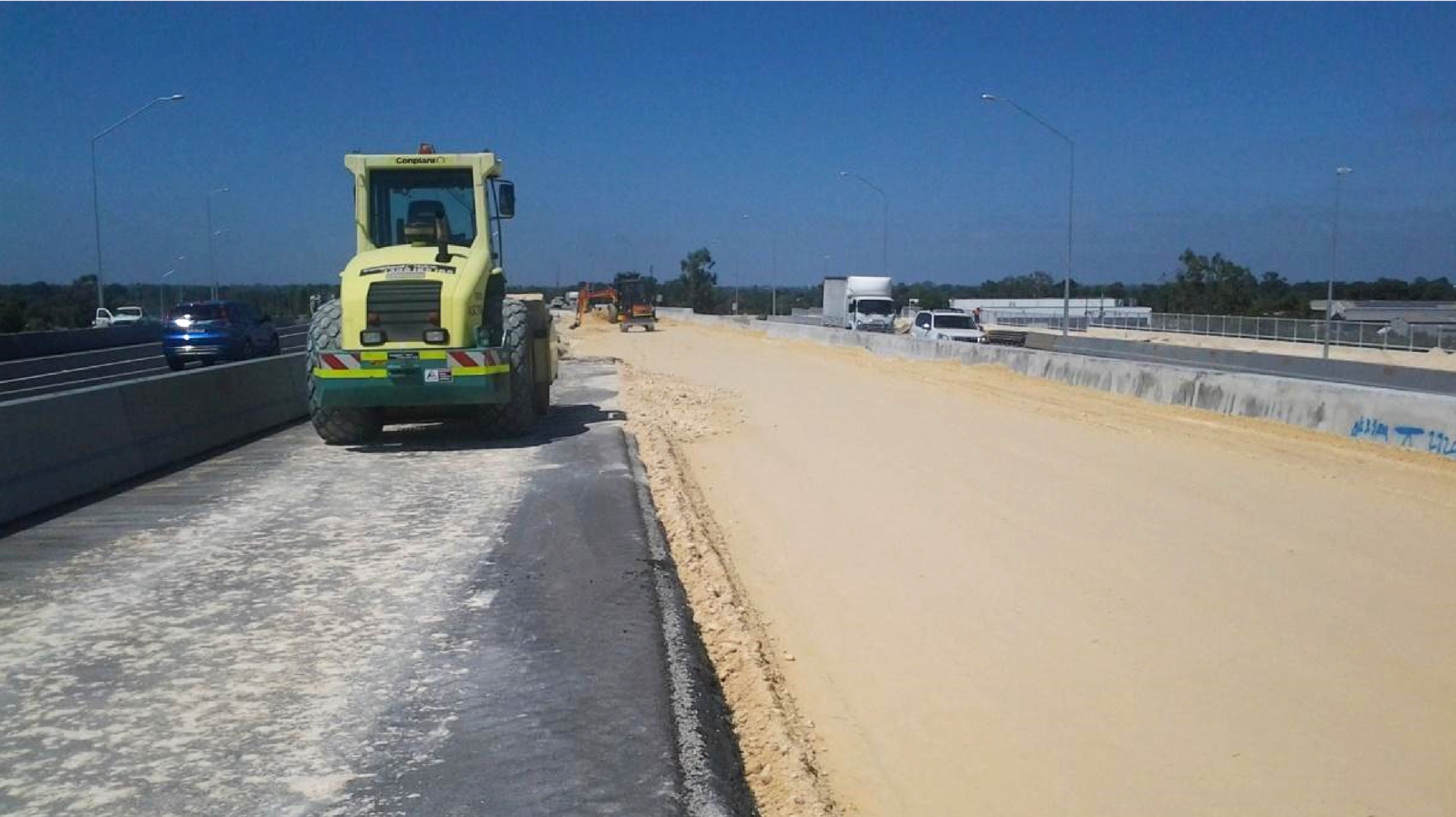 A photograph of the Roe Highway Duplication construction infrastructure project. Specifically a digger providing along the leveled surface.