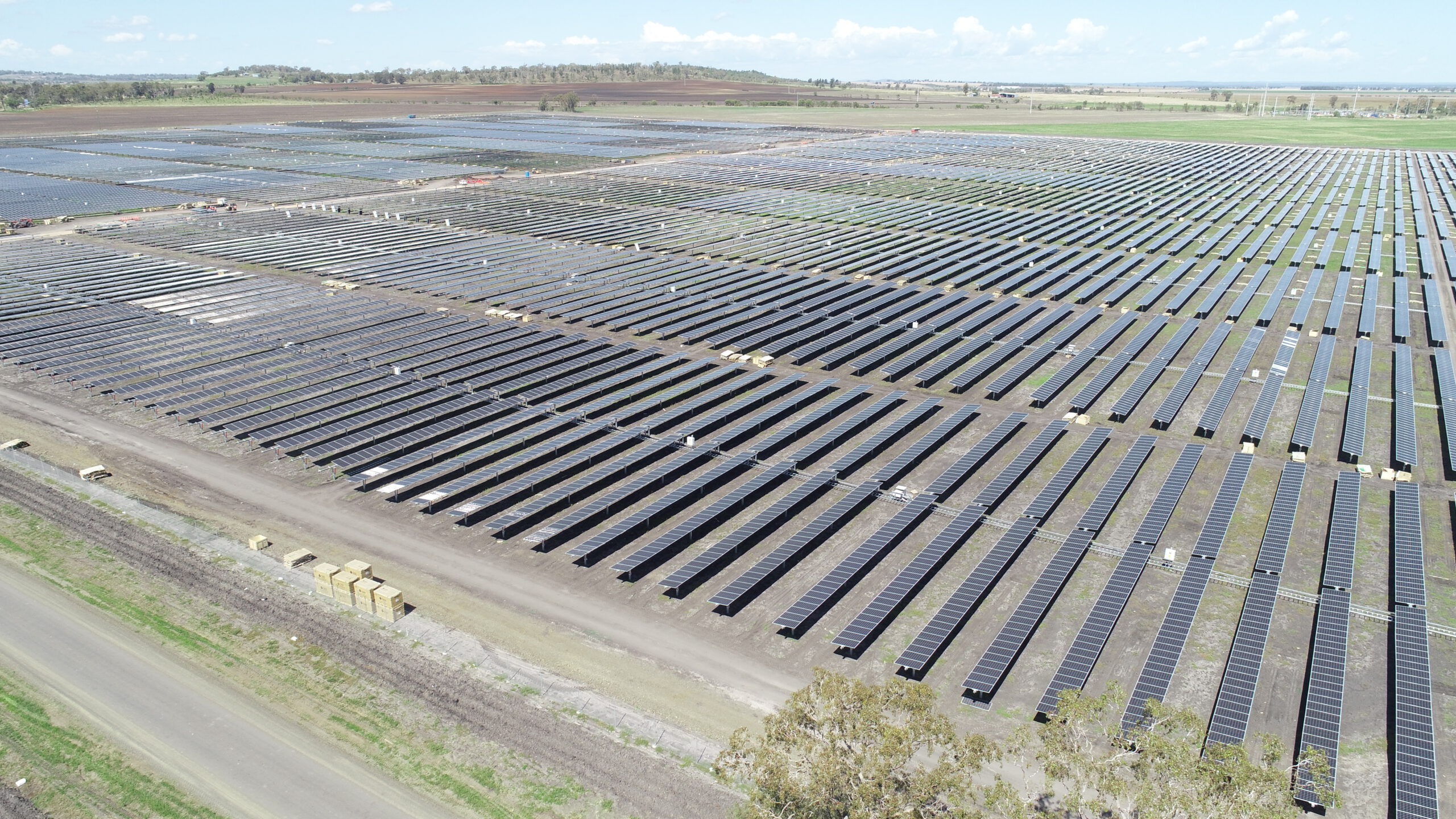 This is a photograph of a completed solar farm during the day, showing the panels are reacting to the positioning of the sun.