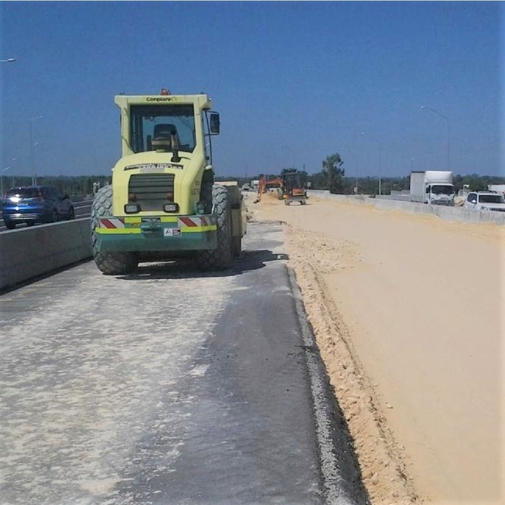 A photograph of the Roe Highway Duplication construction infrastructure project. Specifically a digger providing along the leveled surface.